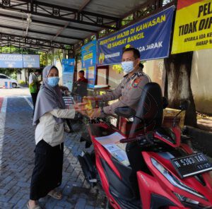 Satlantas Polres Pasuruan Beri Minyak Goreng Pada Ibu Ibu Saat Urus Pajak.